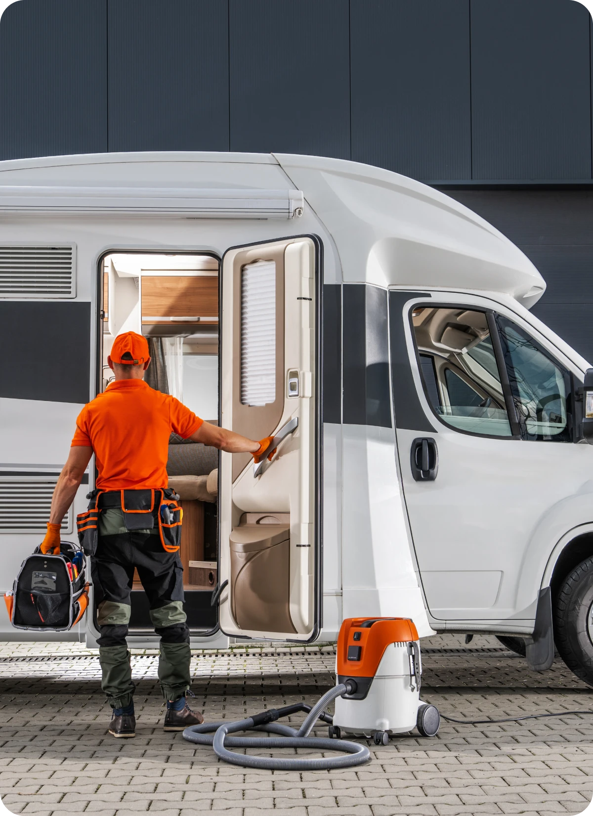 Worker cleaning camper with vacuum