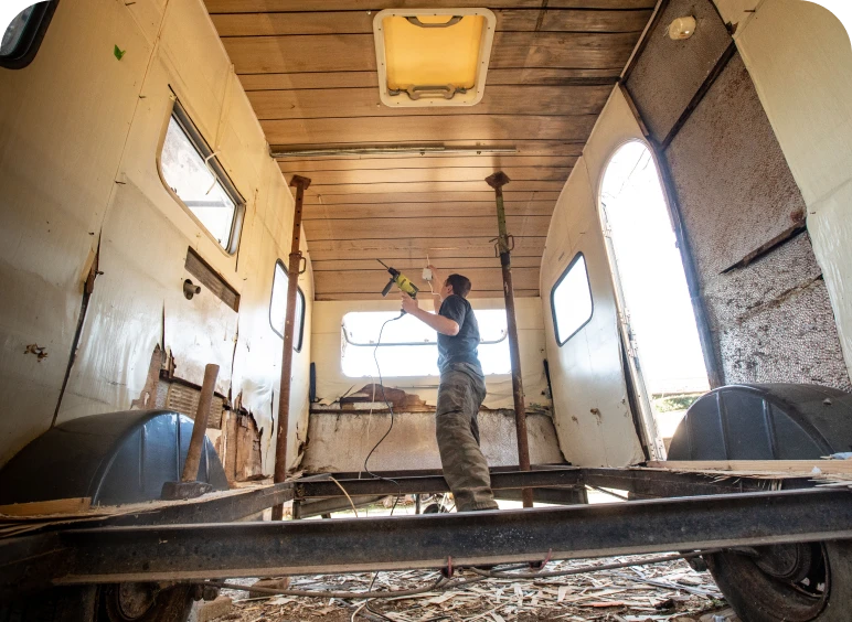 Man refurbishing an empty trailer